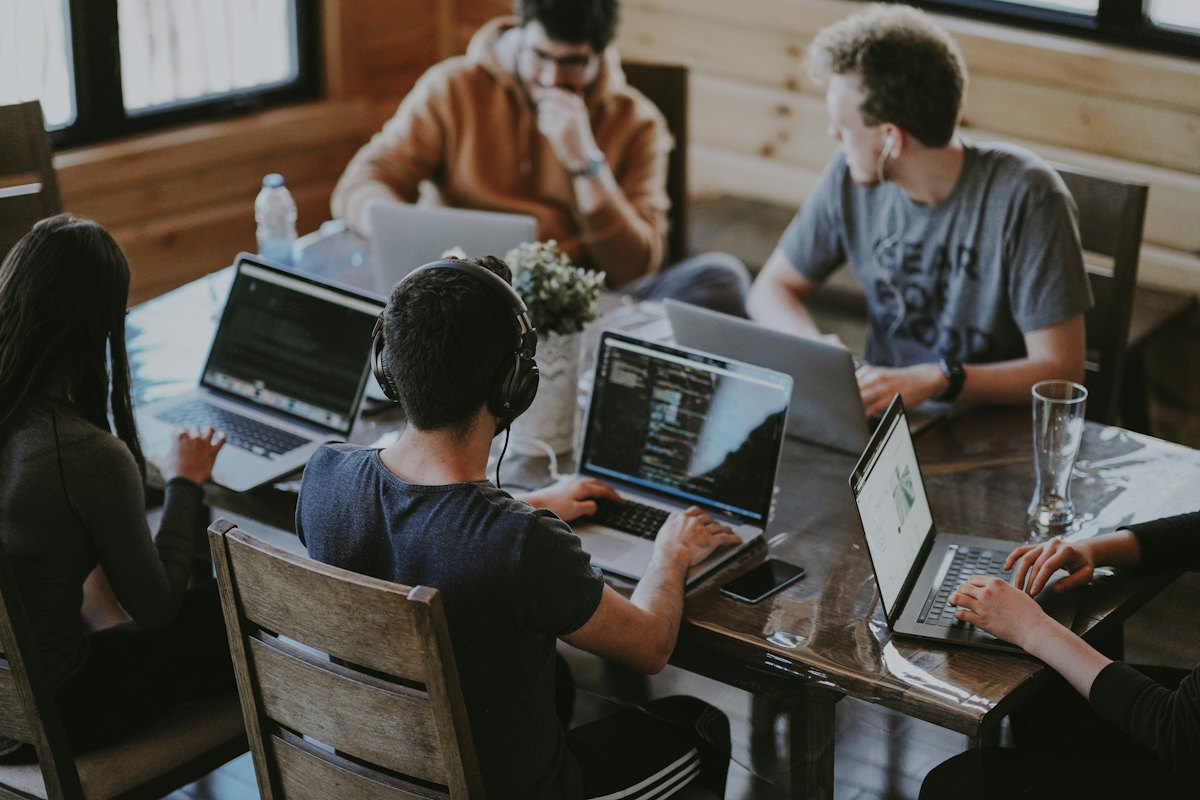 Equipo de trabajo usando computadores portátiles en oficina